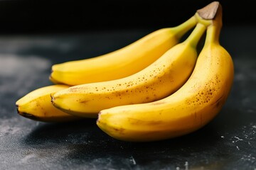 A close-up of yellow bananas against the background of a dark gray concrete table, high-resolution photography.