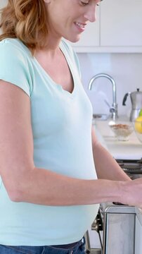Pregnant woman preparing vegetables in kitchen