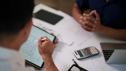A group of engineers reviewing structural designs and material specifications at a meeting table