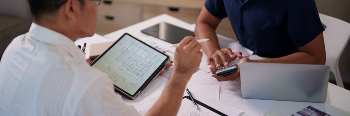 A group of engineers reviewing structural designs and material specifications at a meeting table