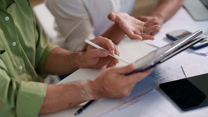 Engineers pointing at architectural drawings and discussing the details of material requirements