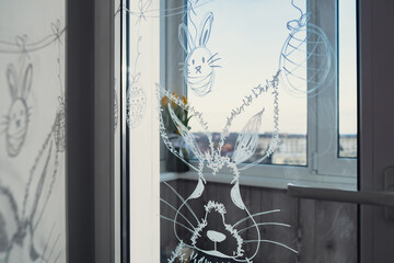 Zero cost responsible holiday decor economically driven. Painted Easter bunny rabbit on window glass indoor at home. Affordable alternative Easter springtime seasonal tradition ideas decoration. Diy