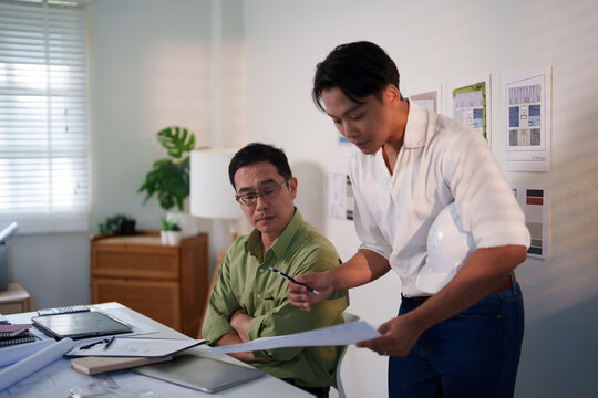 A team of engineers evaluating project risks and discussing construction timelines at their workspace.