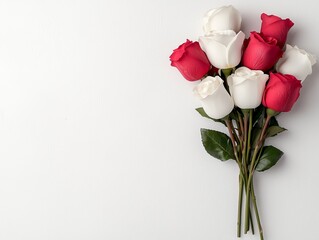 Fototapeta premium A beautiful bouquet of red and white roses arranged elegantly on a light background, symbolizing love and purity.
