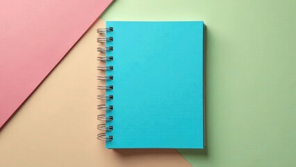 A vibrant teal spiral-bound notebook rests on a pastel background, showcasing a blank cover perfect for your design or message.