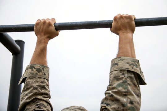 soldier do pull up exercise on bar. Military strength training - Powered by Adobe