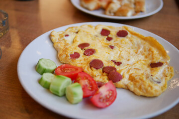 Delicious breakfast with omelet and fresh vegetables on a plate