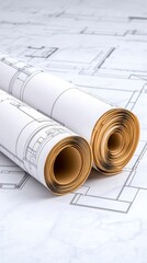 Rolled and unfurled architectural blueprints on a table displaying detailed design plans
