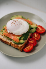 Toast with avocado, fish and poached egg