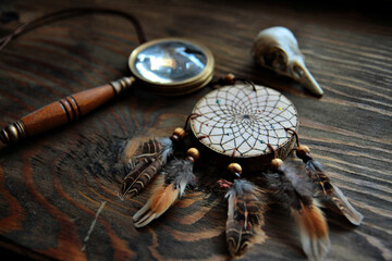 Rustic Dreamcatcher with Feathers and Wooden Handle Magnifying Glass on Wooden Surface