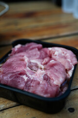 Raw pork marinated served on black tray for Thai style barbecue grill or Moo Krata