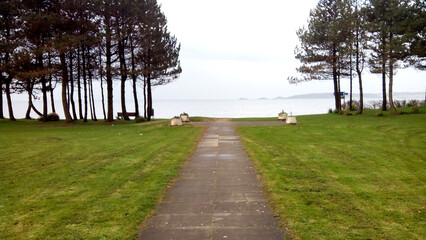 A path leading from a seaside recreation park through trees to the sea