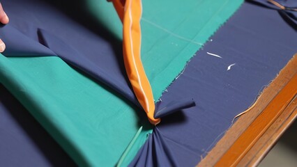 a person is putting ties on a green and orange kite, as they prepare to leave the plane