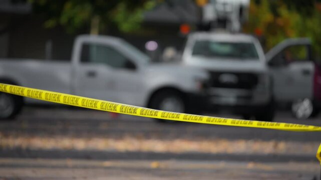 A bright yellow Crime Scene Do Not Cross tape stretched across an urban environment. Car accident