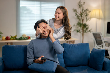 Obraz premium A man and woman are sitting on a blue couch, with the man covering his eyes