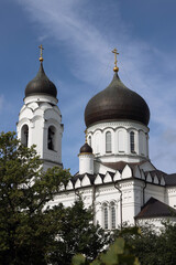 building, domes and crosses of the Orthodox Cathedral of Archangel Michael in the city of Lomonosov (Oranienbaum) in the summer against the blue sky