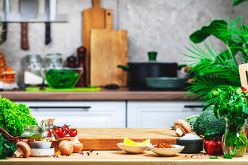 Healthy eating, cooking, food blogging background. Empty oak cutting board with mushrooms, tomatoes, lettuce, vegetables on cozy kitchen with wooden table, kitchenware and utensils