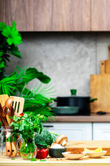 Healthy eating, cooking, food blogging background. Empty oak cutting board with mushrooms, tomatoes, lettuce, vegetables on cozy kitchen with wooden table, kitchenware and utensils