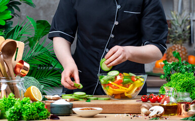 Chef places ​​zucchini and paprika in bowl to prepare saute. Cozy kitchen with wooden table,...