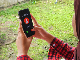 A young woman receiving a spam call from a cellphone (The user interface design used is self-made,...