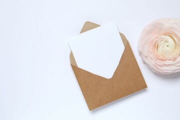 Beautiful composition with pink  ranunculus and paper envelope on a white background