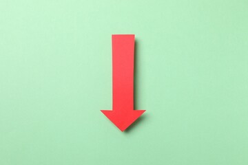 Paper arrow on color background, top view