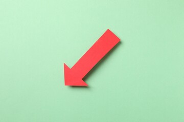 Paper arrow on color background, top view