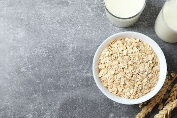 Composition with oatmeal flakes on gray background. Cooking breakfast