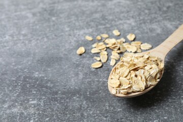 Composition with oatmeal flakes on gray background. Cooking breakfast