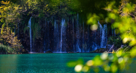 Beauty in spring nature, amazing waterfall in forest. Waterfall and pond. Panoramic beautiful deep forest waterfall. Beautiful view to waterfalls with green forest. The tranquil waters of waterfalls.