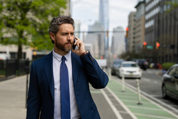 Businessman with phone outdoor. Business talk. Man walk down street talking on the phone. Serious...