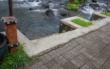 Close-Up of Small Concrete Plaster Stairs by Mountain River with Paved Path and Bathing Steps