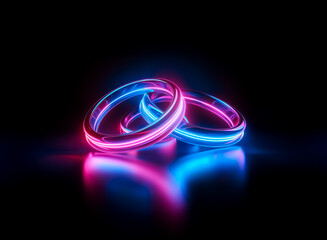 Two glowing rings interlocked, emit vibrant pink and blue neon light against a stark black backdrop. The rings reflect a soft illumination on the dark surface below.