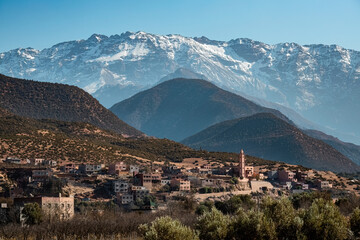 Grand Atlat mountains and Orica valley view with traditional houses and mosque minaret snowy...