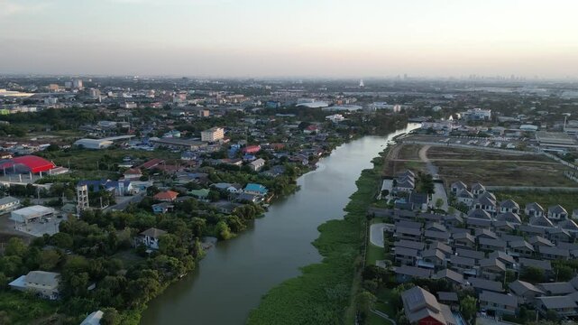 Drone footage of Chao Phraya River in Pathum Thani, Thailand with a view of the surrounding suburbs
