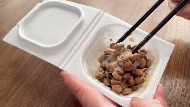 パックの納豆を箸で混ぜる様子