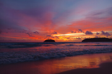 A stunning sunset is casting vibrant hues of color over a tranquil ocean