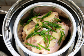 Cooking ginger steamed chicken with spring onion oil.