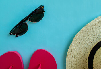 Summer vacation. Flip flops, sunglasses and a hat on a blue background.