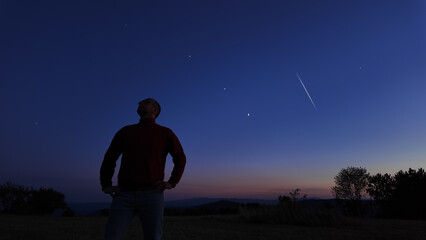 Silhouette of a man and countryside under the stars and Moonlight.