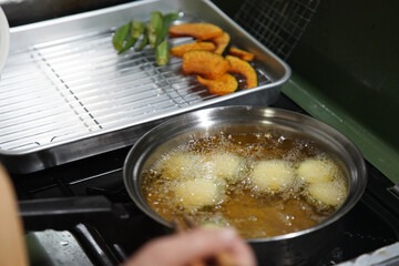 野菜の素揚げをする女性