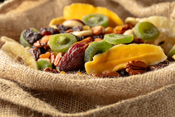 Dried tropical fruits and nuts in burlap bag.