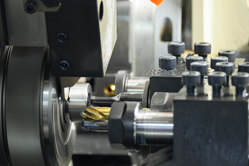 The  multi tasking CNC lathe machine swiss type drilling the metal fitting parts.