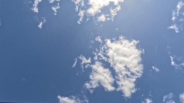 4K Timelapse of clouds passing overhead, with beautiful sunlight filtering through the top of screen.