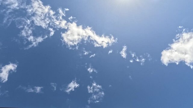 4K Timelapse of clouds passing overhead, with beautiful sunlight filtering through the top of screen.
