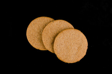 Thin gingerbread cookies on a black background