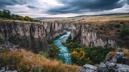 A deep gorge with a turquoise river flowing between towering cliffs
