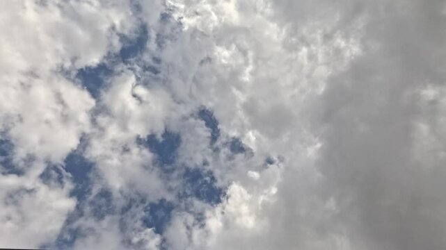 4K Timelapse of clouds passing overhead, with beautiful sunlight filtering through the top of screen.
