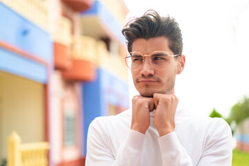 Obraz premium Young caucasian man at outdoors With glasses and tired