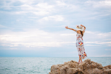 Happy traveler asian woman with hat and dress relax and travel in Wong Amat Beach at Pattaya Thailand Summer holiday vacation concept